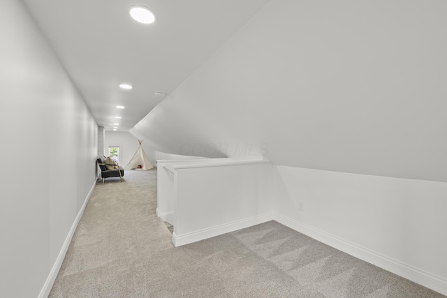 additional living space with lofted ceiling and light carpet