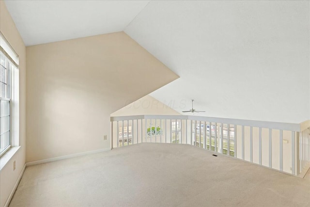 unfurnished room with ceiling fan, light colored carpet, and lofted ceiling