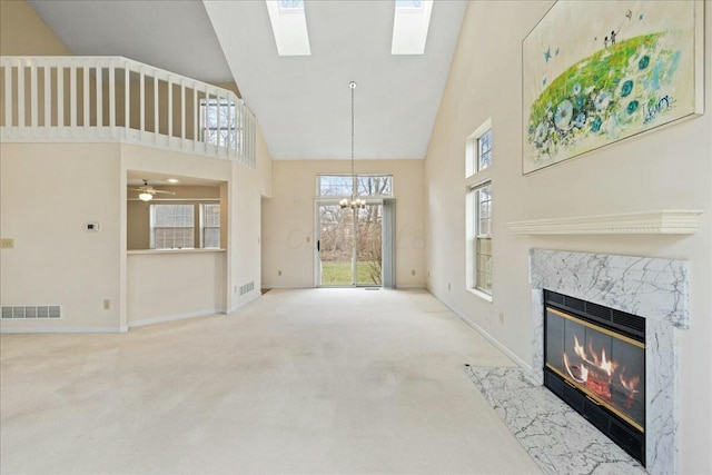 living room featuring carpet flooring, a wealth of natural light, a notable chandelier, and a fireplace