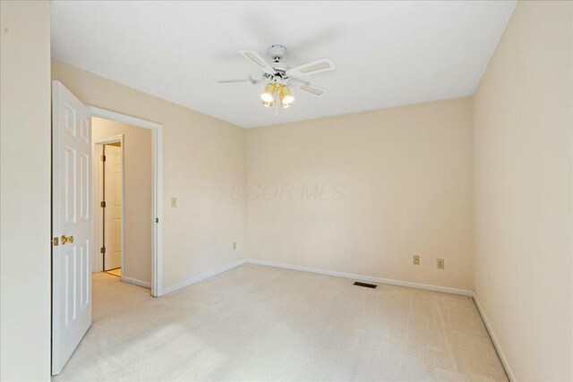 carpeted spare room featuring ceiling fan