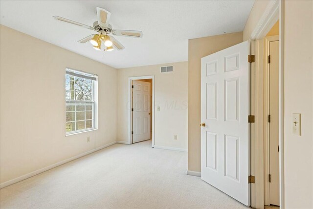 unfurnished bedroom featuring light carpet and ceiling fan