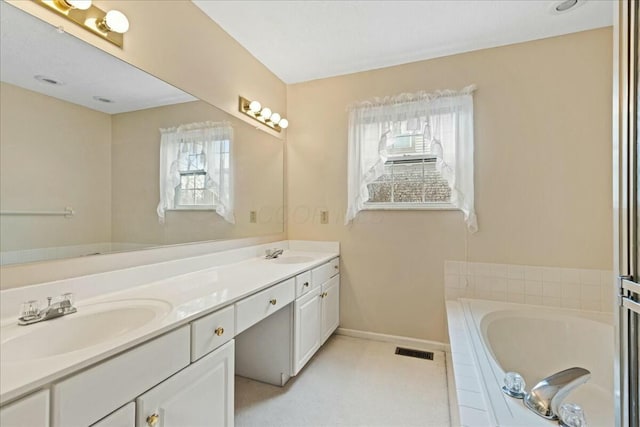 bathroom with vanity and a relaxing tiled tub