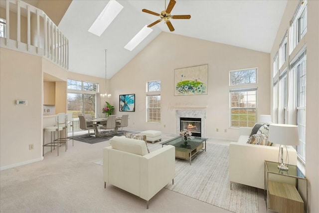 living room featuring a healthy amount of sunlight, light colored carpet, a fireplace, and high vaulted ceiling