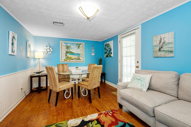 dining room featuring hardwood / wood-style flooring and a textured ceiling