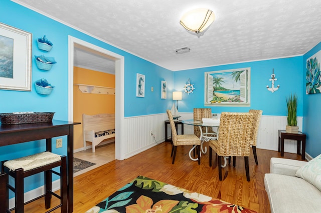 dining area featuring hardwood / wood-style flooring and a textured ceiling