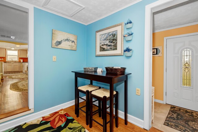 interior space featuring crown molding, sink, and light wood-type flooring