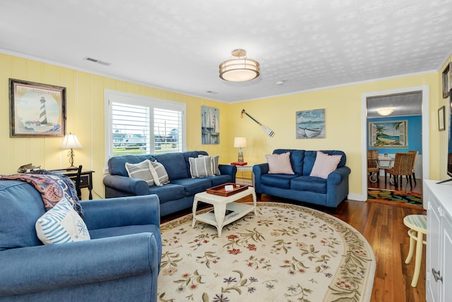 living room featuring crown molding, dark hardwood / wood-style floors, and a textured ceiling