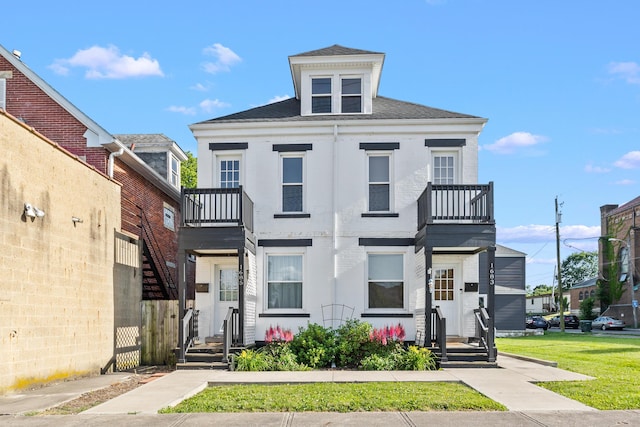 view of front of property with a balcony and a front lawn