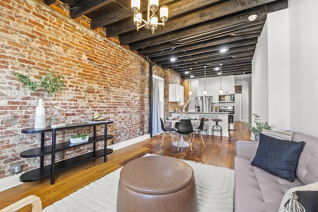 living room featuring beamed ceiling, brick wall, and light hardwood / wood-style flooring