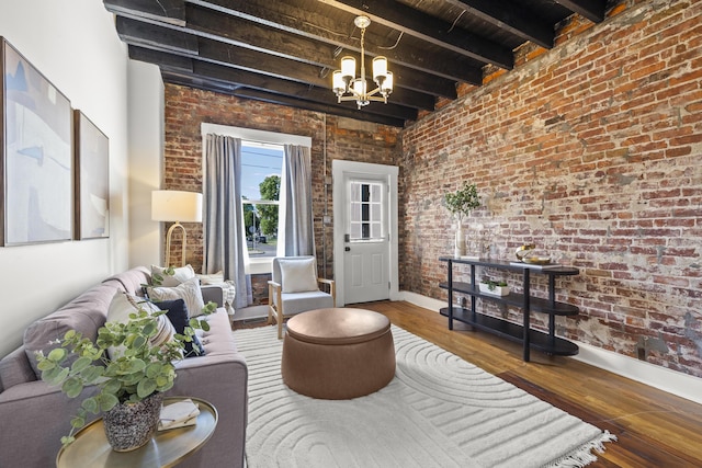 living room with beamed ceiling, wood-type flooring, brick wall, and a notable chandelier