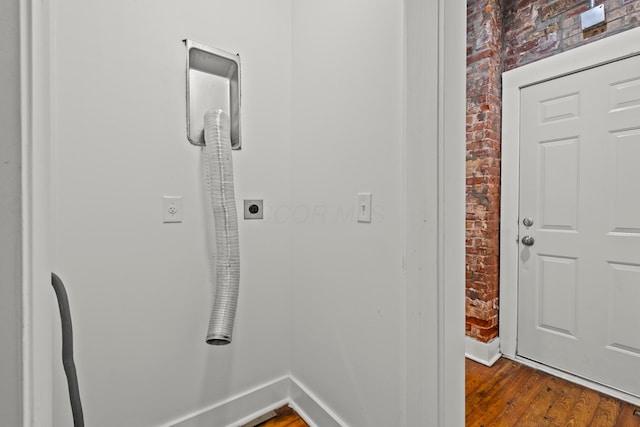 hall featuring hardwood / wood-style flooring and brick wall