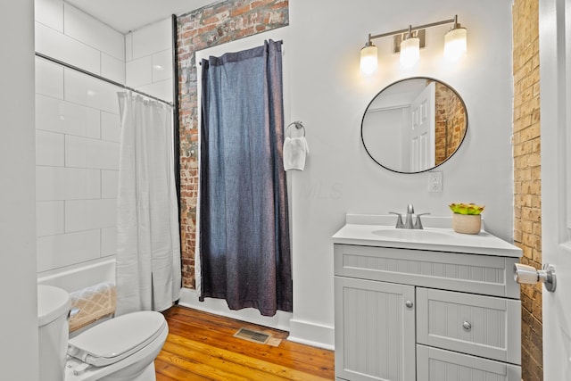 full bathroom with toilet, wood-type flooring, vanity, shower / bath combination with curtain, and brick wall