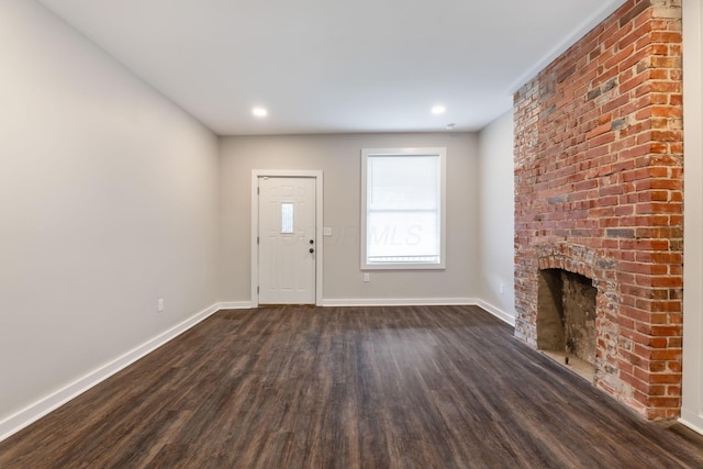 unfurnished living room featuring a fireplace and dark hardwood / wood-style floors