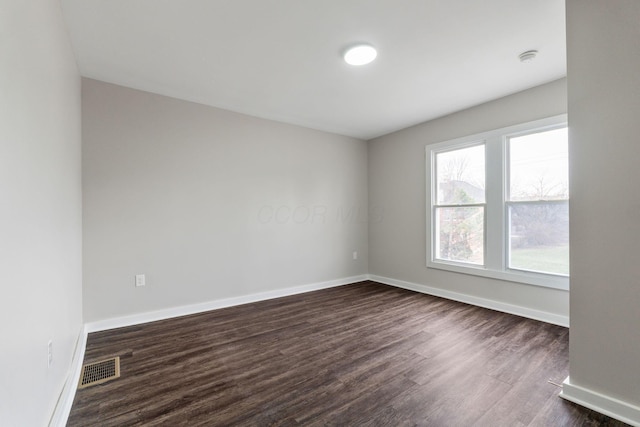 spare room with dark hardwood / wood-style flooring