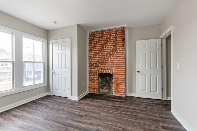 unfurnished living room with a fireplace and dark hardwood / wood-style floors