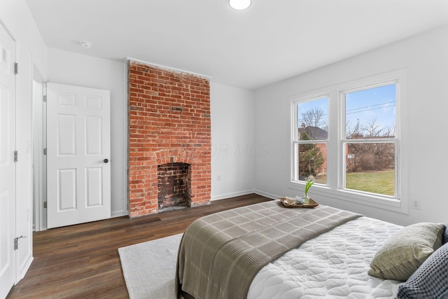 bedroom with dark hardwood / wood-style floors and a fireplace