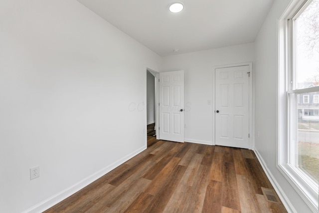 unfurnished bedroom with dark wood-type flooring