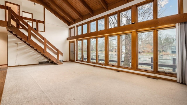 unfurnished living room featuring a water view, high vaulted ceiling, wooden ceiling, carpet flooring, and beamed ceiling