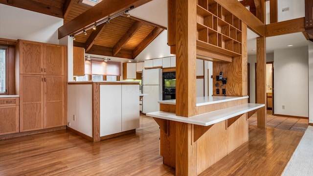 kitchen with wood ceiling, black double oven, white fridge, beamed ceiling, and light wood-type flooring