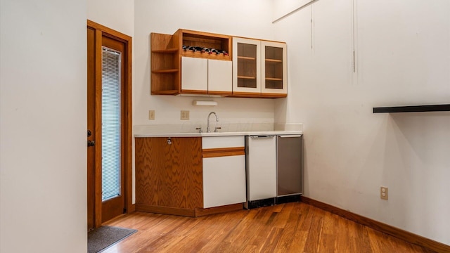 kitchen featuring sink, dishwasher, and light hardwood / wood-style floors