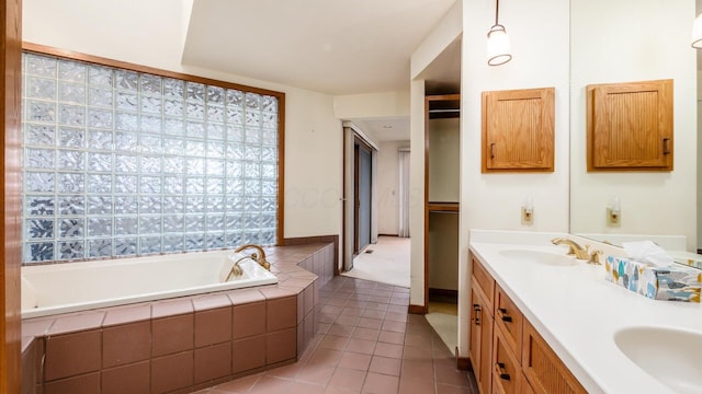 bathroom featuring vanity, tile patterned flooring, and tiled tub