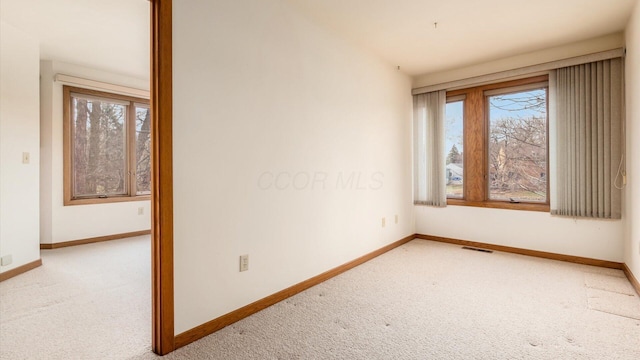 carpeted empty room featuring a wealth of natural light