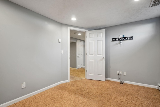 empty room featuring light carpet and a textured ceiling