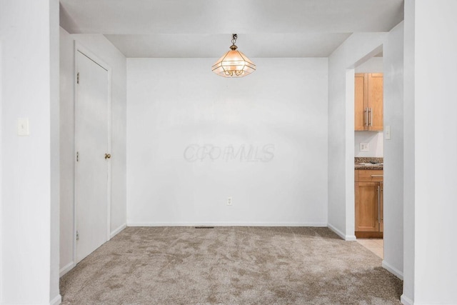 unfurnished room featuring light colored carpet