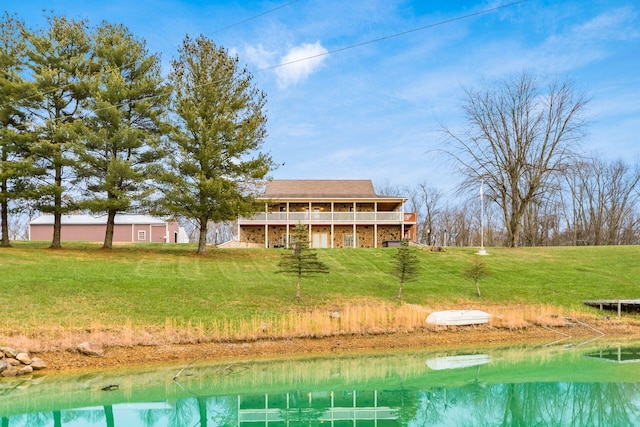 rear view of property featuring a lawn and a water view