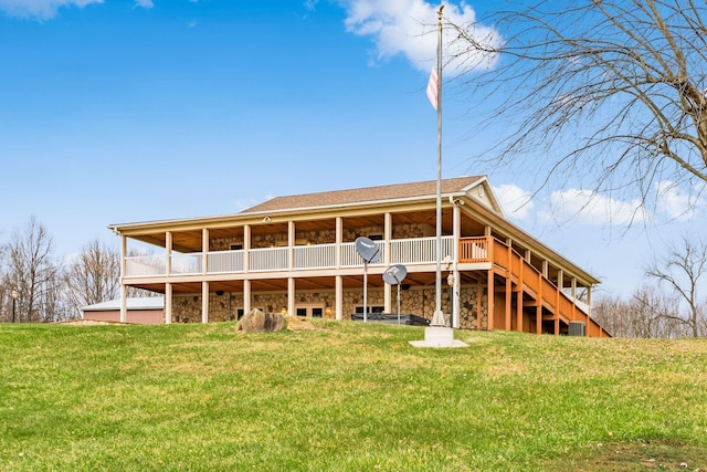 rear view of property with a deck and a lawn