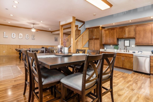 interior space featuring ceiling fan, wooden walls, sink, and light hardwood / wood-style floors