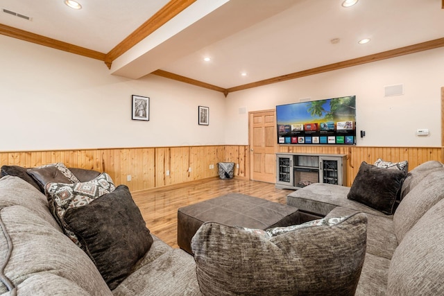 living room featuring hardwood / wood-style flooring, crown molding, wooden walls, and beam ceiling