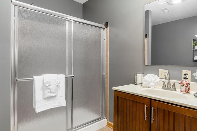 bathroom featuring vanity and a shower with shower door