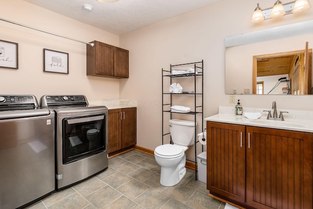 laundry area with separate washer and dryer, sink, and a textured ceiling