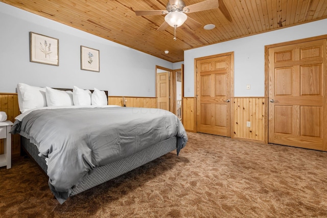 bedroom with carpet flooring, wooden ceiling, and wooden walls