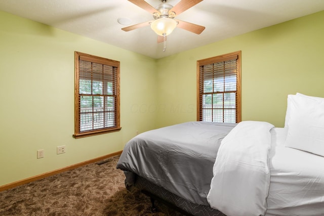 carpeted bedroom featuring multiple windows and ceiling fan