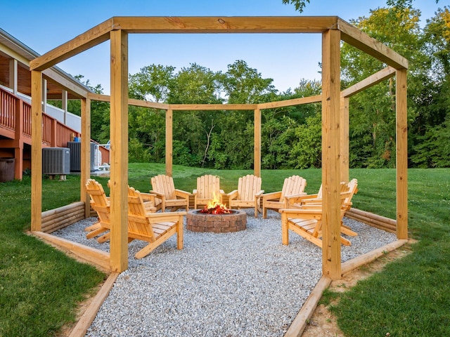 view of jungle gym with a patio area, a wooden deck, a yard, cooling unit, and a fire pit