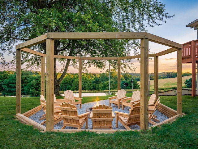 patio terrace at dusk with an outdoor fire pit and a yard