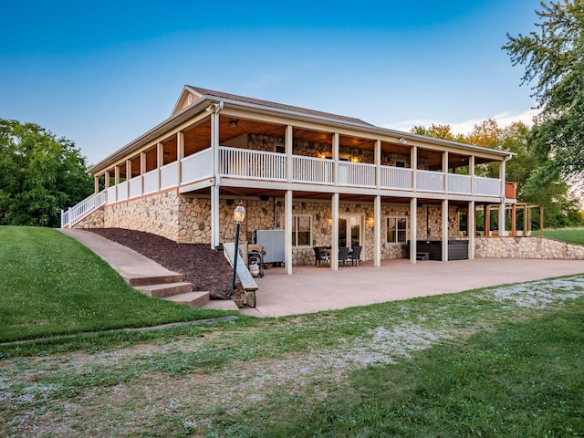 back of property featuring a yard and a patio