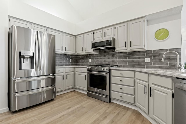 kitchen featuring sink, appliances with stainless steel finishes, gray cabinetry, backsplash, and light hardwood / wood-style floors