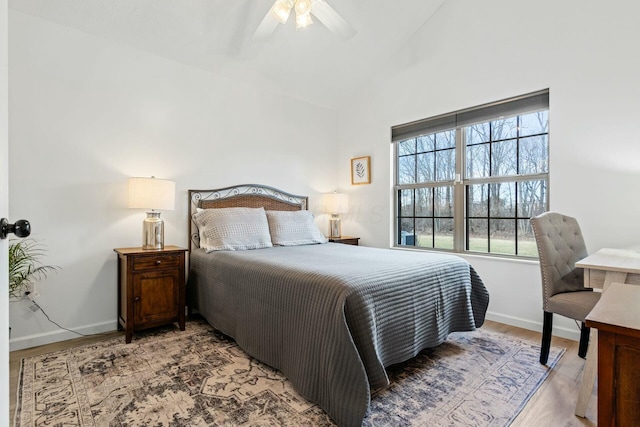 bedroom with ceiling fan, wood-type flooring, and vaulted ceiling