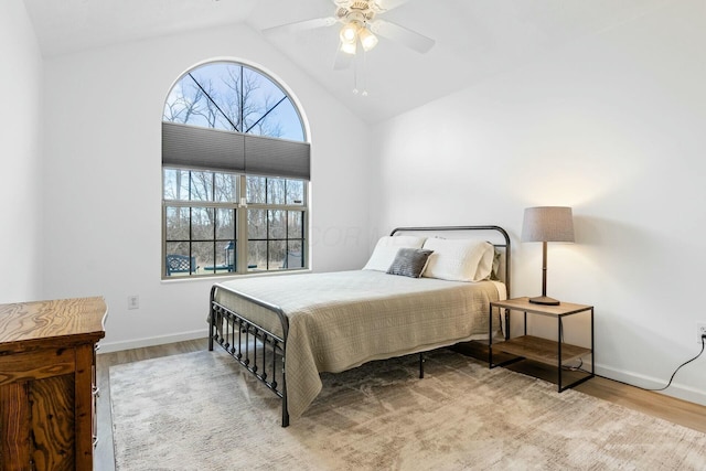 bedroom with ceiling fan, high vaulted ceiling, and light wood-type flooring