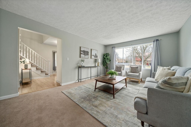 carpeted living room featuring a textured ceiling