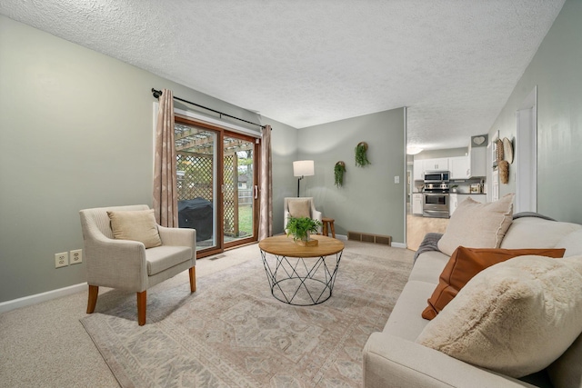 living room featuring light colored carpet and a textured ceiling