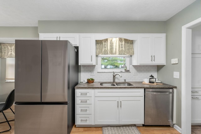 kitchen featuring tasteful backsplash, sink, white cabinets, and appliances with stainless steel finishes