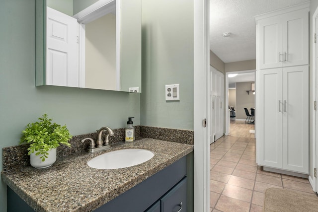 bathroom featuring vanity, tile patterned flooring, and a textured ceiling