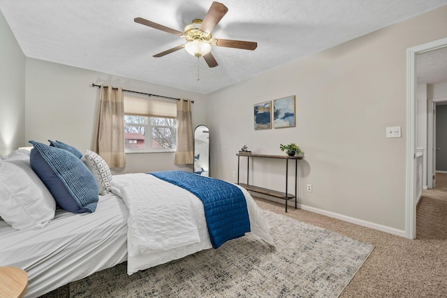 carpeted bedroom with ceiling fan and a textured ceiling