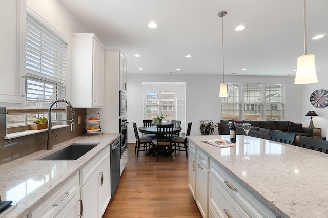 kitchen featuring appliances with stainless steel finishes, sink, pendant lighting, and white cabinets