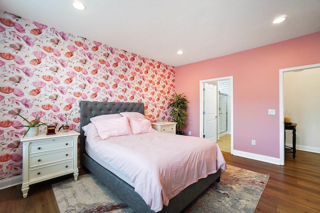 bedroom featuring ensuite bathroom and dark hardwood / wood-style flooring