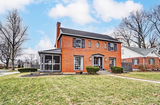 colonial home featuring a sunroom and a front lawn